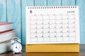 The June 2023 Monthly desk calendar for the organizer to plan 2023 year with alarm clock and books on wooden table