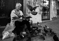 25 June 2022, An old lady feeding street doves in Porto.