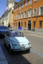 June 2022 Parma, Italy: Old street of the city with a blue retro fiat 500 car across the orange building Royalty Free Stock Photo