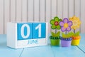 June 1st. Image of june 1 wooden color calendar on blue background with flowers. First summer day. Empty space for text