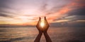 June summer sun solstice concept with silhouette of happy woman `s hands relaxing, meditating and holding sunset against Royalty Free Stock Photo