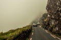 Two cars meet along the narrow scenic Conor Pass roads in county Kerry, Ireland, on a foggy day