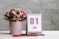 June 01. 01th day of the month, calendar date.A delicate bouquet of flowers in a pink vase, two pencils and a calendar with a date