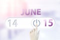 June 15th. Day 15 of month, Calendar date.Hand finger switches pointing calendar date on sunlight office background. Summer month