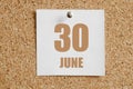 june 30. 30th day of the month, calendar date.White calendar sheet attached to brown cork board.Spring month, day of the Royalty Free Stock Photo