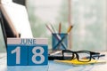 June 18th. Day 18 of month, wooden color calendar on account office background. Summer time. Empty space for text