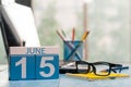 June 15th. Day 15 of month, wooden color calendar on freelance workplace background. Summer time. Empty space for text