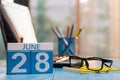 June 28th. Day 28 of month, wooden color calendar on hard worker workbench background. Summer time. Empty space for text