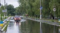 June 21, Vyshenky Ukraine. Consequences of the shower. Car splashes through a large puddle on a flooded street.
