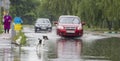 June 21, Vyshenky Ukraine. Consequences of the shower. Car splashes through a large puddle on a flooded street.