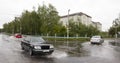 June 21, Vyshenky Ukraine. Consequences of the shower. Car splashes through a large puddle on a flooded street.