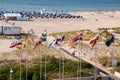 Drone view of beautiful beach in Warnemunde, Germany on Baltic Sea beach huts, bathers and flags