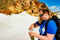 June 16 2018, Whistler Canada: Editorial photograph of a female hiker filling her water bottle with snow