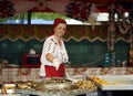 Woman preparing street food at Transylvanian Flea Market in Negreni, Romania. Royalty Free Stock Photo