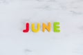 June word written with colorful letters on white marble stone background Royalty Free Stock Photo