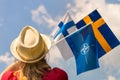 June 6, A young woman holds the flags of Finland, Sweden and NATO in her hand, Supporting the accession of new countries to the