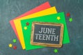 Juneteenth freedom day concept with colorful paper, blackboard and stars on black background. Top view, flat lay Royalty Free Stock Photo