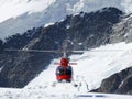 Jungfrau, Switzerlan. Red helicopter on high mountain snow