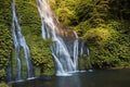 Jungle cascade waterfall in tropical rainforest with rock and crystal pond. Scenic waterfall with fresh water and rainbow in