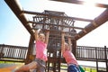 Jungle gym adventures. two little girls hanging on the monkey bars at the playground.