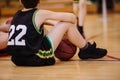 Junior basketball player sitting on the floor in basketball court Royalty Free Stock Photo