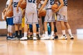 Junior Basketball Team During Training Class Standing Together and Huddling in Circle. Players Listening to Coaches'