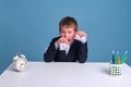 Junior boy in school uniform with dollar and us money torn in half on blue background