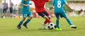 Junior competition between players running and kicking a soccer ball Royalty Free Stock Photo