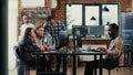 Junior developers collaborating on group project compiling algorithm asking senior programer for help