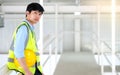 Junior engineer standing in the plant holding helmet and looking outside with copy space Royalty Free Stock Photo