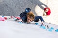 Junior female Athlete on climbing Wall and belaying referee