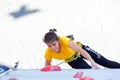 Junior female Athlete makes hard move on climbing wall