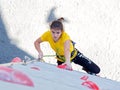 Junior female Athlete makes hard move on climbing wall