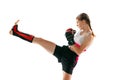 Junior female MMA fighter in sports uniform and gloves training isolated on white background. Concept of sport