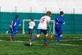 Junior football match. Boys in blue white sportswear play soccer match on football pitch. Football stadium, grass field