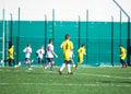 Junior football match. Soccer game for youth players. Boys in yell and white uniform playing soccer match. Football stadium and gr