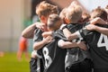 Junior football team stacking hands before school tournament match