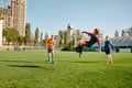 Junior forward jumping to kick ball with leg taking part in football match Royalty Free Stock Photo