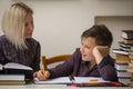 A junior high school student does his homework with a female tutor. Royalty Free Stock Photo