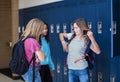 Junior High school Students talking and standing by their locker in a school hallway