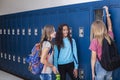 Junior High school Students talking and standing by their locker in a school hallway Royalty Free Stock Photo