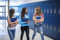 Junior High school Students talking and standing by their locker in a school hallway