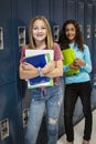 Junior High school Students talking and standing by their locker in a school hallway Royalty Free Stock Photo