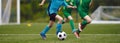 Junior-level soccer competition between players running and kicking soccer. ball. Anonymous youth junior athletes Royalty Free Stock Photo