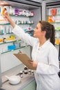 Junior pharmacist taking medicine from shelf Royalty Free Stock Photo