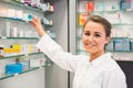 Junior pharmacist taking medicine from shelf Royalty Free Stock Photo