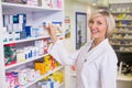 Junior pharmacist taking medicine from shelf Royalty Free Stock Photo