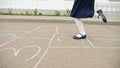 Junior school girl plays hopscotch in empty schoolyard Royalty Free Stock Photo