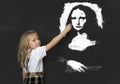 Junior schoolgirl with blonde hair drawing and painting with chalk La Gioconda amazing replica Royalty Free Stock Photo