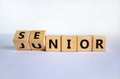 From junior to senior symbol. Turned cubes and changed the word `junior` to `senior`. Beautiful white background, copy space. Royalty Free Stock Photo
